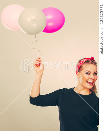 Smiling crazy girl having fun with balloons. 129825771