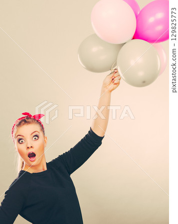 Smiling crazy girl having fun with balloons. 129825773
