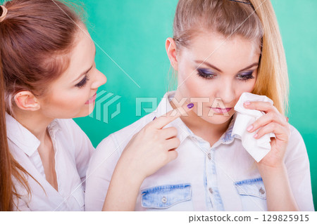 Sad woman crying and being consoled by friend. 129825915