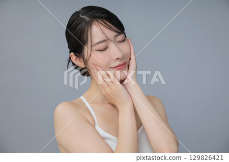 Beauty image: Young woman checking her skin condition 129826421