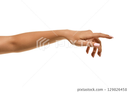 Female hand with white manicure in elegant reaching gesture isolated. Female hand with white manicure in elegant reaching gesture isolated. 129826458