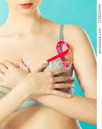woman in bra with breast cancer awareness ribbon woman in bra with breast cancer awareness ribbon 129826469
