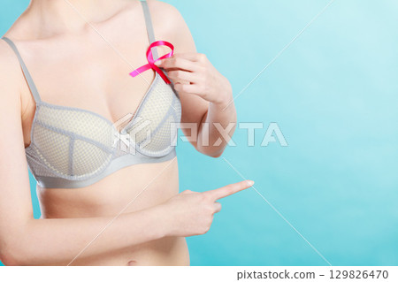 woman in bra with breast cancer awareness ribbon 129826470