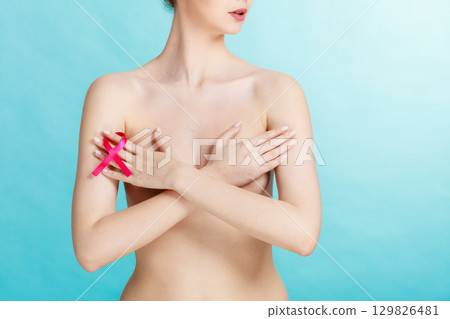 Naked woman with breast cancer awareness ribbon Naked woman with breast cancer awareness ribbon 129826481