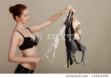 woman choosing bras to wear woman choosing bras to wear 129826494
