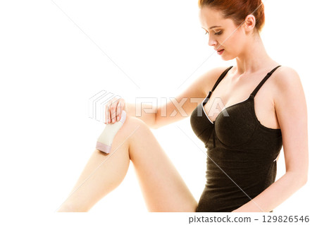 Woman shaving her legs with electric razor Woman shaving her legs with electric razor 129826546
