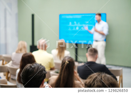 Presenter leading a business seminar with audience in focus 129826850