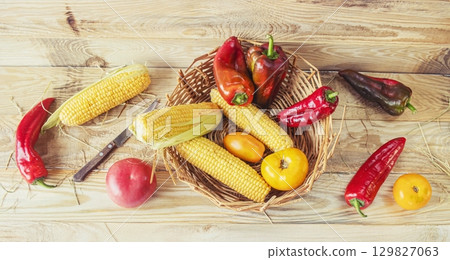 Fresh vegetables in a basket on a wooden background. Healthy food. Cooking from fresh farm vegetables for lunch. Fresh vegetables in a basket on a wooden background. Healthy food. Cooking from fresh farm vegetables for lunch. 129827063