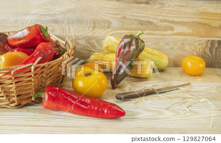 Fresh vegetables in a basket on a wooden background. Healthy food. Cooking from fresh farm vegetables for lunch. Fresh vegetables in a basket on a wooden background. Healthy food. Cooking from fresh farm vegetables for lunch. 129827064