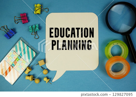 Education Planning text with magnifying glass on blue background 129827095