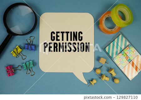 Getting Permission text with magnifying glass on blue background 129827110