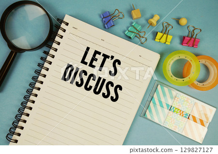 Let's Discuss text with magnifying glass on blue background 129827127