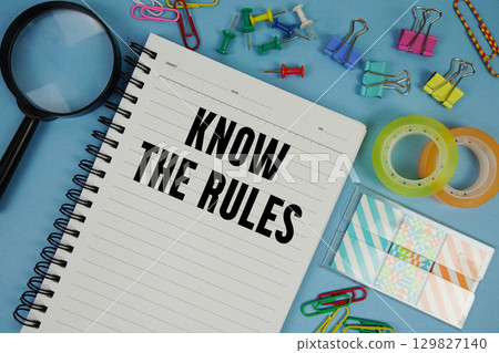 Know The Rules text with magnifying glass on blue background 129827140