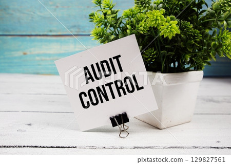 Audit Control text written on paper card on wooden background 129827561