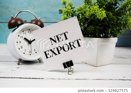 Net Export text written on paper card with alarm clock on wooden background 129827575