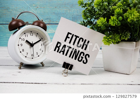Fitch Ratings text written on paper card with alarm clock on wooden background Fitch Ratings text written on paper card with alarm clock on wooden background 129827579