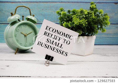 Economic Relief To Small Businesses text written on paper card with alarm clock on wooden background Economic Relief To Small Businesses text written on paper card with alarm clock on wooden background 129827583