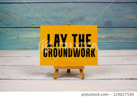 Lay the Groundwork text written on paper card on wooden background Lay the Groundwork text written on paper card on wooden background 129827589