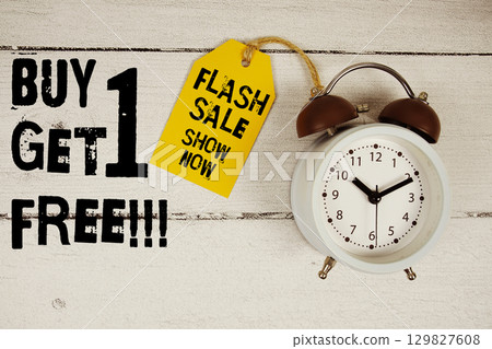 Buy 1 Get 1 Free!!! Shop Now text with alarm clock on wooden background Buy 1 Get 1 Free!!! Shop Now text with alarm clock on wooden background 129827608