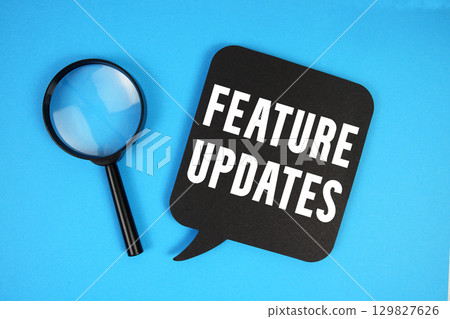 Feature Updates text with magnifying glass on blue background Feature Updates text with magnifying glass on blue background 129827626