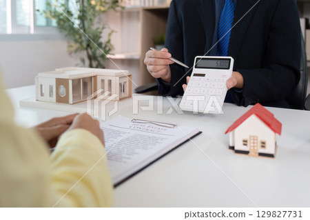 Real Estate Professional Discussing Financial Calculations with Client. 129827731