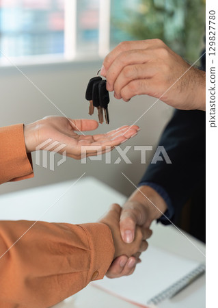 Real Estate Key Exchange. Agent handing keys to buyer after agreement. 129827780