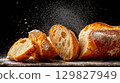 Ciabatta bread slices arranged on a dark surface 129827949
