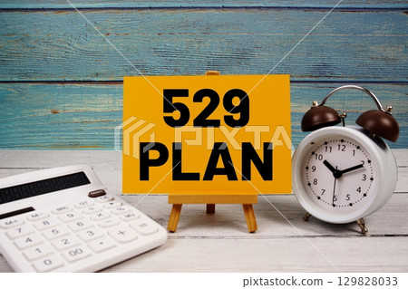 529 Plan text written on paper card with calculator and alarm clock on wooden background 129828033
