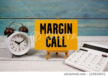 Margin Call text written on paper card with calculator and alarm clock on wooden background Margin Call text written on paper card with calculator and alarm clock on wooden background 129828041