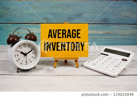 Average Inventory text written on paper card with calculator and alarm clock on wooden background Average Inventory text written on paper card with calculator and alarm clock on wooden background 129828046