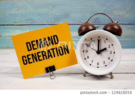 Demand Generation text written on paper card with alarm clock on wooden background 129828058