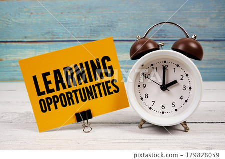 Learning opportunities text written on paper card with alarm clock on wooden background 129828059
