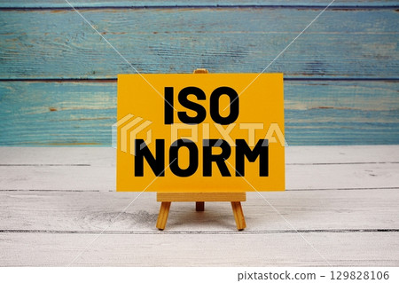 ISO NORM text written on paper card on wooden background 129828106