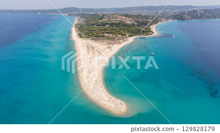 Breathtaking aerial view of Possidi cape, a unique sand formation creating a hook shaped peninsula in Kassandra, Halkidiki, Greece, surrounded by the turquoise Aegean sea 129828179