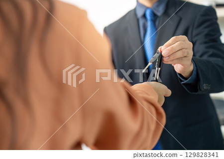 Client Receiving Keys from Real Estate Agent 129828341