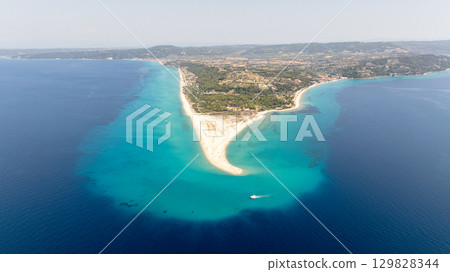 Aerial view of Possidi cape, a narrow strip of land extending into the Aegean sea, featuring turquoise waters, sandy beach, and green vegetation, in Kassandra, Greece Aerial view of Possidi cape, a narrow strip of land extending into the Aegean sea, featuring turquoise waters, sandy beach, and green vegetation, in Kassandra, Greece 129828344