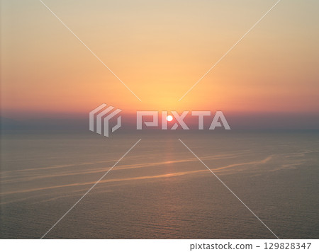 The sun sets over the Aegean sea in Kassandra, Greece, painting the sky with vibrant colors, creating a peaceful and serene atmosphere perfect for relaxation and mindfulness 129828347