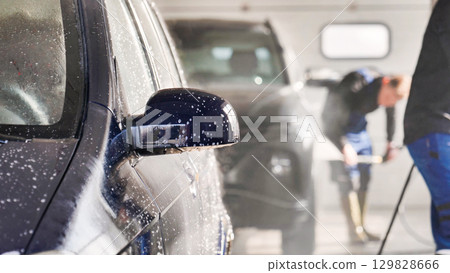 Car wash workers cleaning vehicle with high pressure water jet Car wash workers cleaning vehicle with high pressure water jet 129828666
