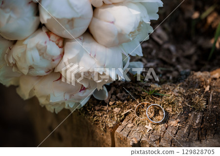 White Peony Bouquet with Wedding Rings on Tree Bark, Romantic Still Life - Floral Arrangement, Engagement, Love, Marriage Celebration 129828705