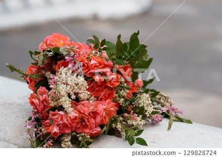 Romantic Wedding Rings and Coral Peach Roses Bouquet on Stone Ledge, Soft Focus, Celebration of Love and Commitment. 129828724
