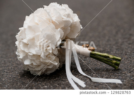 Wedding Rings and Hydrangea Bouquet Still Life, White Flowers, Marriage Symbolism, Elegant Celebration, Romantic Scene, Soft Light, Detailed Texture 129828763
