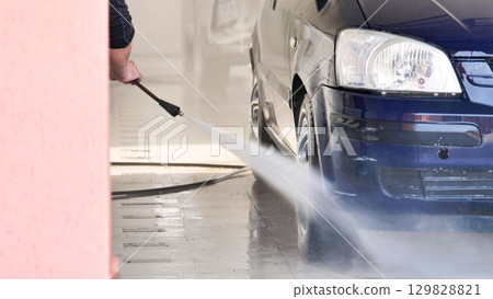 Car wash worker using high pressure water jet cleaning vehicle Car wash worker using high pressure water jet cleaning vehicle 129828821