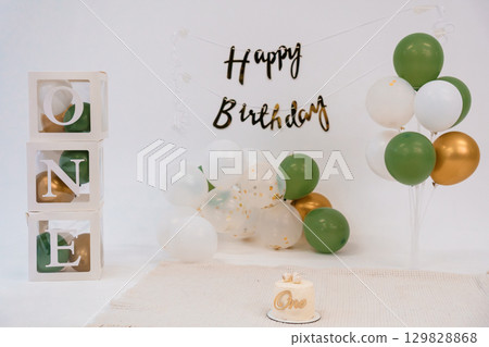 Stylish "ONE" First Birthday Backdrop with Gold and Green Balloons, Cake, Letter Blocks, Celebrating Milestone, Minimalist Party Decoration, Modern Style. 129828868