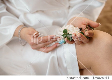 Bride Carefully Pinning Boutonniere to Lapel of Grooms Suit, Wedding Florals, Silk Dress, Romantic Soft Focus, White and Green Color Scheme Bride Carefully Pinning Boutonniere to Lapel of Grooms Suit, Wedding Florals, Silk Dress, Romantic Soft Focus, White and Green Color Scheme 129828911
