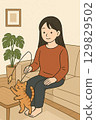 A woman and a cat playing in the living room 129829502