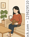 Woman taking a break with a cat in the living room 2 129829510