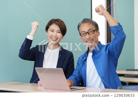 Seniors attending a computer class and a teacher Seniors attending a computer class and a teacher 129830633