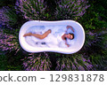 a woman immersed in a bathtub in a flowery meadow 129831878