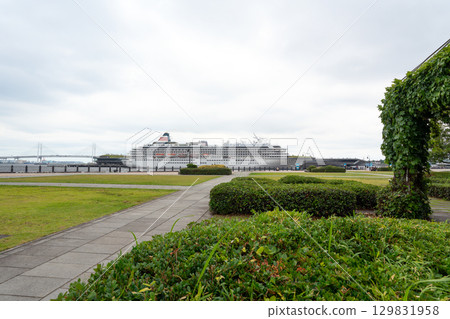A large passenger ship moored at Osanbashi Pier and Yokohama Bay Bridge seen from Red Brick Park 129831958