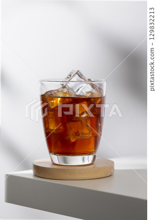 Iced americano in a glass on a white table in the cafe. Iced americano in a glass on a white table in the cafe. 129832213
